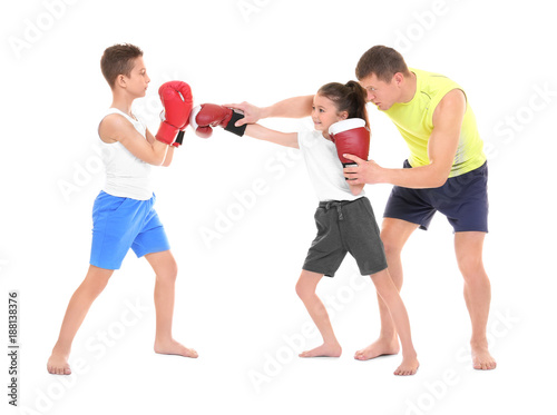 Cute little children training with boxing coach on white background
