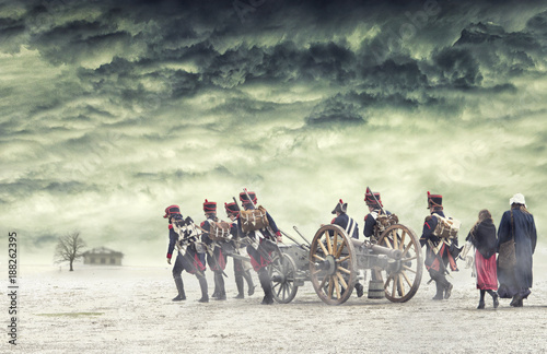 Napoleonic soldiers and women marching and pulling a cannon in plain land, countryside with stormy clouds. Soldiers going towards a damaged abonded house. Coming home