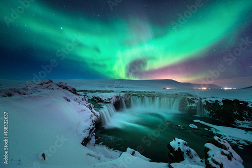 Godafoss waterfall with stunning aurora in the night sky of winter Iceland