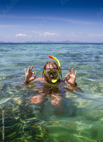 Young man snorkeling in clear shallow tropical sea