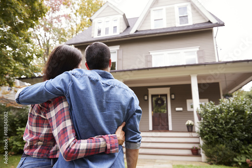 Rear View Of Loving Couple Looking At House