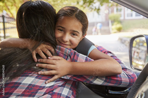 Mother In Car Dropping Off Daughter In Front Of School Gates