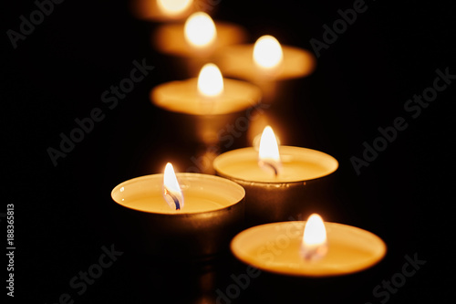 Burning votive candles on dark background