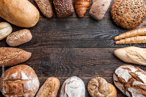 Delicious fresh bread on wooden background