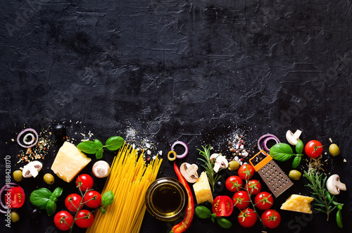 Food ingredients for italian pasta, spaghetti on black stone slate background. Copy space of your text