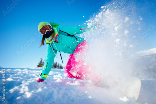 Snowboarder on snowboard rides through snow, explosion. Freeride snowboarding in Sheregesh Ski Resort