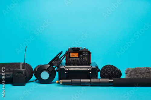 equipment for field audio recording on blue background. Windshield, microphone, radio system, boompole, recorder, portable case and headphones