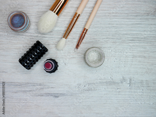 Wooden white background with brushes color and lipstick