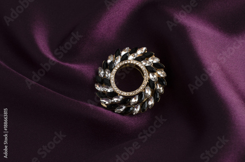 round brooch with gems isolated on silk