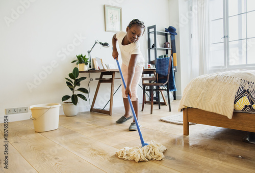 Young teen girl sweeping up the floor