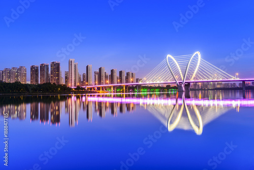 Modern bridge and skyscraper at dusk. Located in Shenyang, Liaoning, China.