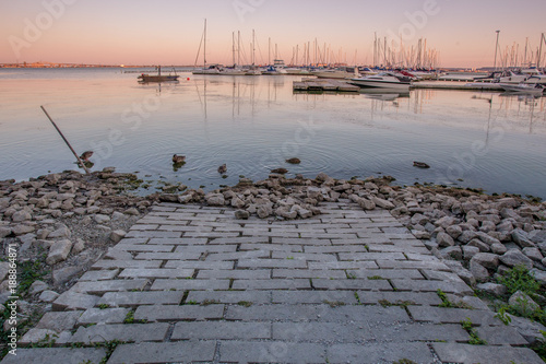 Sunset view of brick path leading into harbour with marina in background in Burlington, Ontario