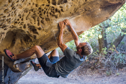 Man Bouldering Outside in a Cave