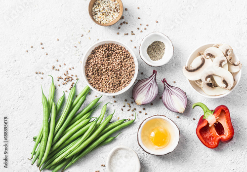 Flat lay healthy vegetarian food ingredients for lunch on a light background, top view. Buckwheat, green beans, sweet peppers, red onion, mushrooms - clean eating vegetarian food concept