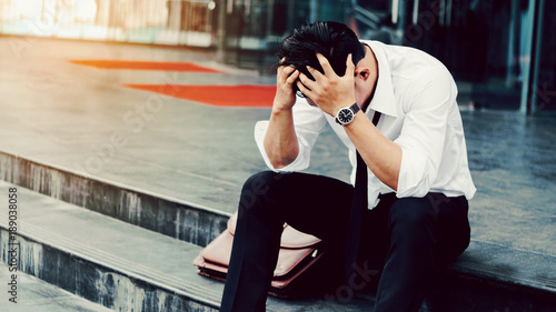 Unemployed Tired or stressed businessman sitting on the walkway after work Stressed businessman concept