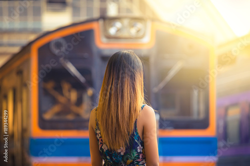 Woman with hat near railroad tracks waiting for train