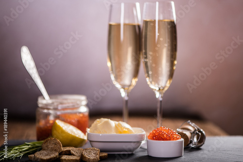 Side view of caviar and champagne on wood table 