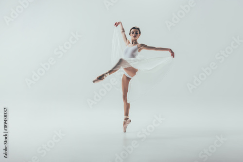 young elegant ballerina dancing in studio, isolated on white