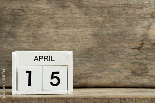 White block calendar present date 15 and month April on wood background