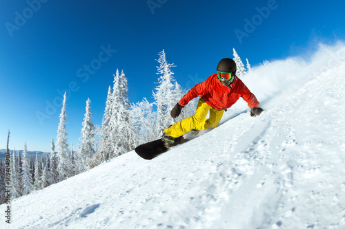 Very fast snowboarder slides at ski slope
