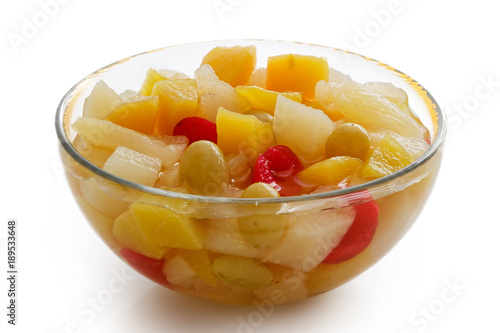 Glass bowl of fruit cocktail isolated on white.