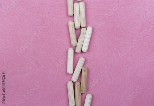 Drewniane kołki na różowym tle 