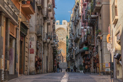 Cathedral of Tarragona at the end in the street in the middle of the trade of the old quarter of the Catalan city in Spain