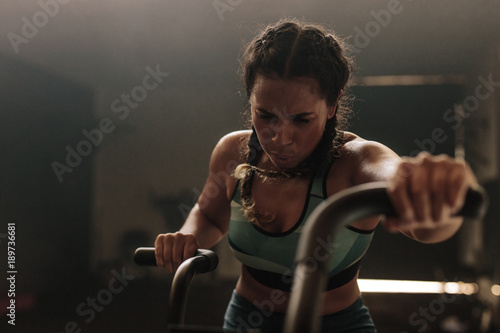 Woman exercising hard on gym bike