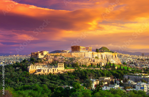 Acropolis with Parthenon. View through a frame with green plants, trees, ancient marbles and cityscape, Athens, Greece.