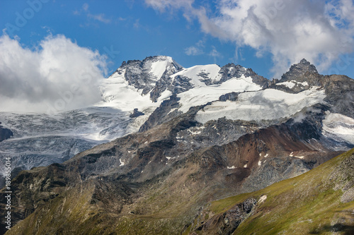 Hiking in Cogne valley, Aosta, Italy. View of Gran Paradiso Group with the namesake summit and Herbetet summit on the right. Photo taken from TsaPlana, a place outside the park boundaries.