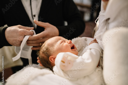 baptism baby. cute little head of a girl under holy water at chr