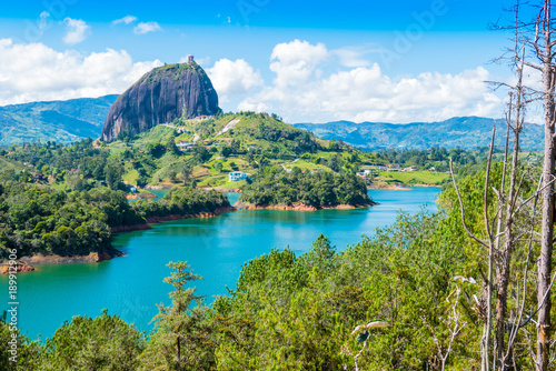 Colombia Guatape, landscape view of Penol lake and the famous homonym big rock in a sunny day with blue sky a famous tourist destination