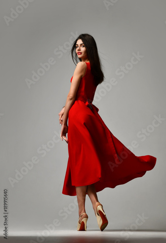 Pretty brunette woman in formal red dress stiletto heels shoes