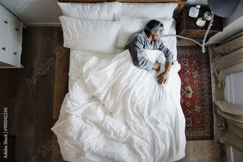 Man sleeping with an anti-snoring mask on