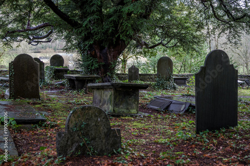 An overgrown historic grave yard in North Wales with some slate head stones