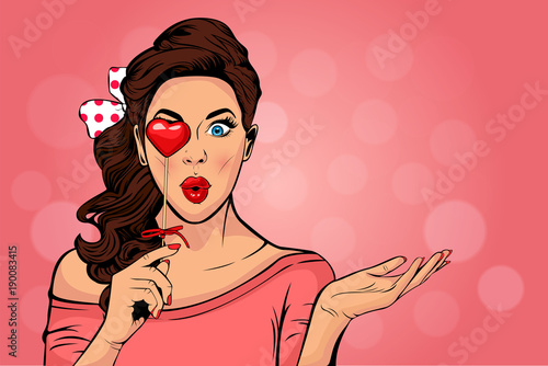 Wow pop art face of surprised fashion girl open mouth with Valentine Heart in hand. Love. Beautiful young woman model pointing hand, advertising gesture. 