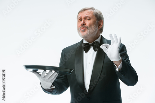 Senior waiter holding tray