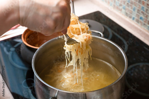 the cook transfer sauerkraut from pot in saucepan