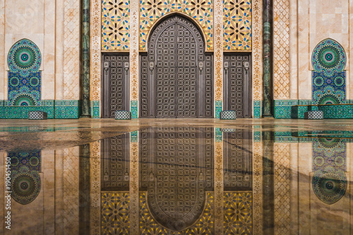 view of Hassan II mosque's big gate reflected on rain water - Casablanca - Morocco