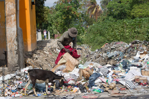 man digging thru the trash in third world country