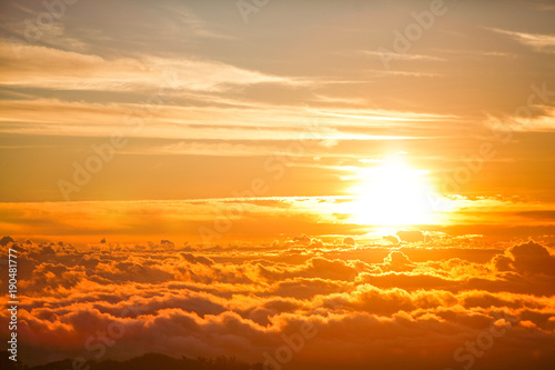 Beautiful aerial view above clouds with sunset. Airplane view