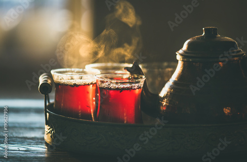 Tradycyjna turecka herbata gotowana na parze w szklankach tulipanów z miedzianym garnkiem na tacy vintage