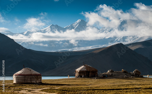 The yurt village in front of Karakul Lake in Xinjiang Uighur Autonomous Region of China is the highest lake of the Pamir plateau, with Muztagh Ata peak of the Kunlun mountains, in the background.