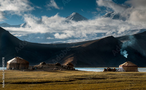 The yurt village in front of Karakul Lake in Xinjiang Uighur Autonomous Region of China is the highest lake of the Pamir plateau, with Muztagh Ata peak of the Kunlun mountains, in the background.