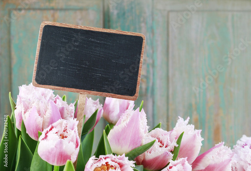 Bouquet of pink tulips and blank blackboard label