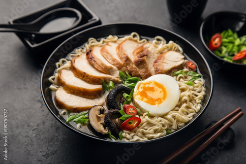 japanese ramen noodle with chicken, shiitake mushroms and egg in black bowl,