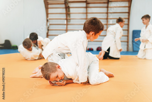 Chłopcy w mundurach ćwiczą sztukę walki