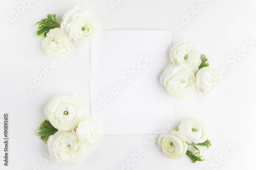 Floral frame made of white flowers and leaves on white background. Floral background. Flat lay, top view.