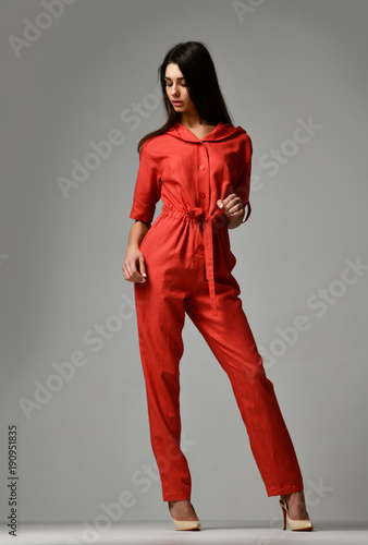 Young beautiful woman posing in new red fashion costume dress with pants and hood