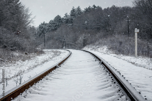 winter landscape, the railway track goes into the distance, on the sides - the forest